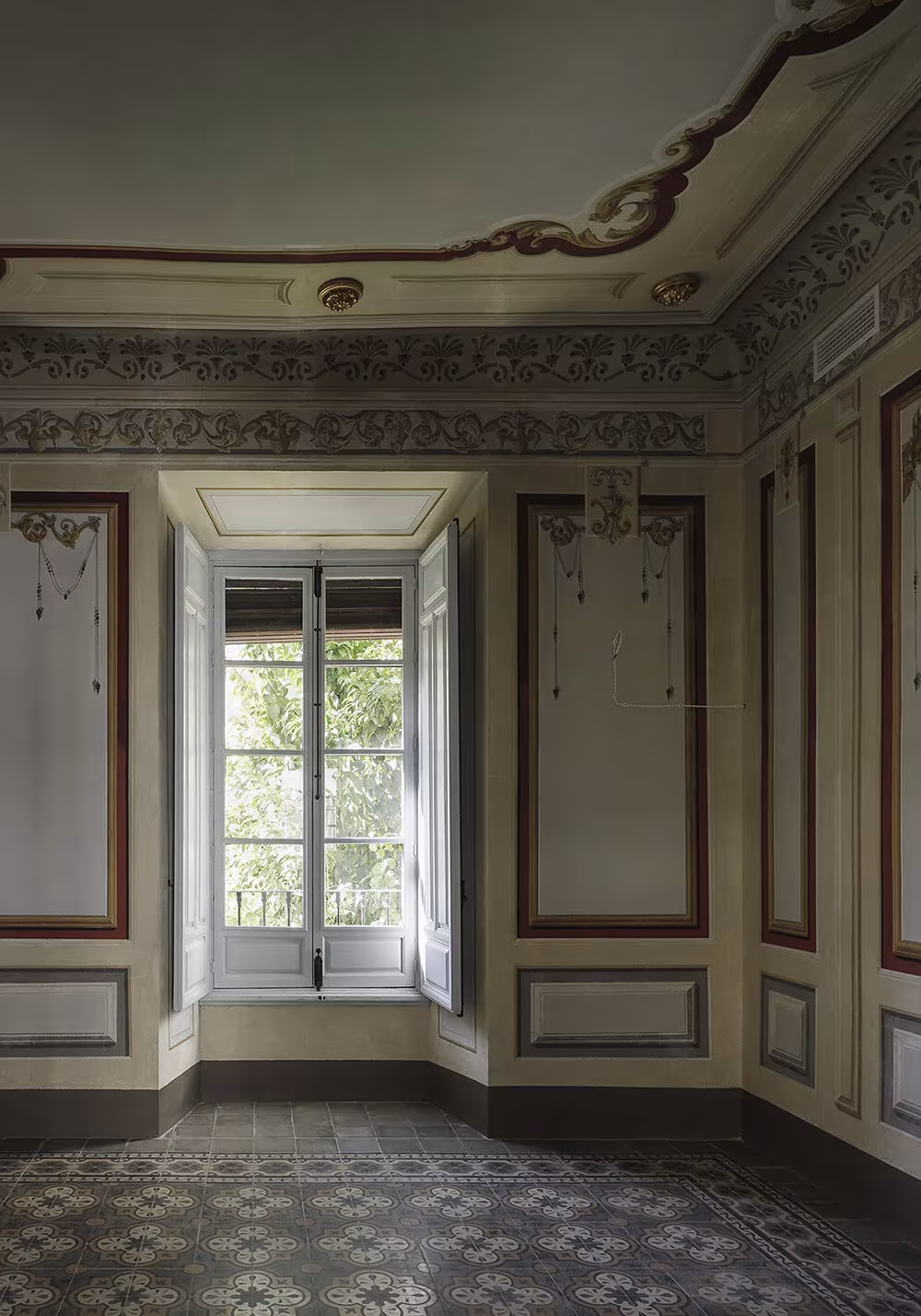 Sala histórica del Colegio San Fernando con frisos pintados, molduras en el techo y balcón de madera