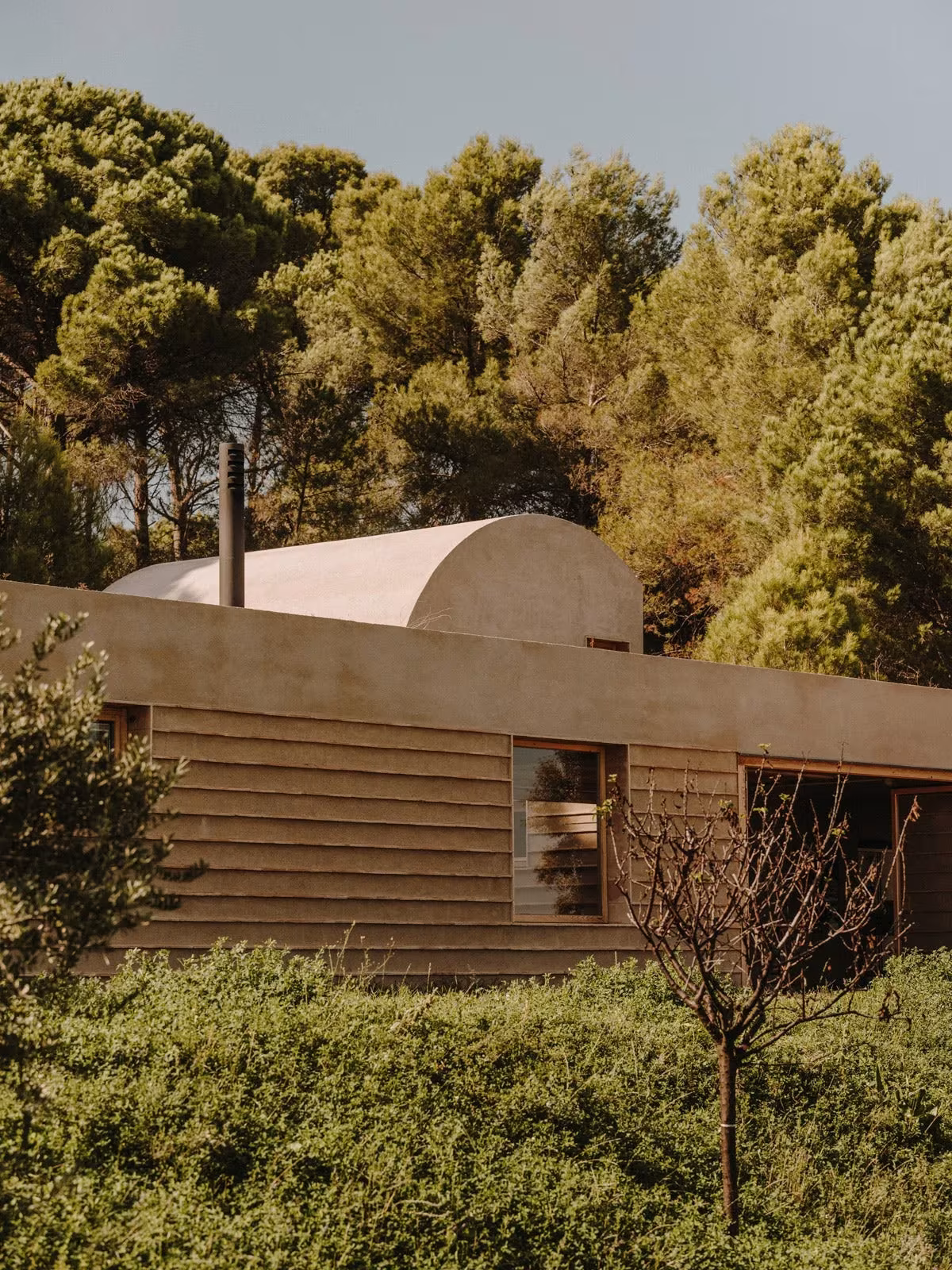 Casa Ter de Mesura entre pinos y encinas, con volumen abovedado y muros de piedra en hiladas