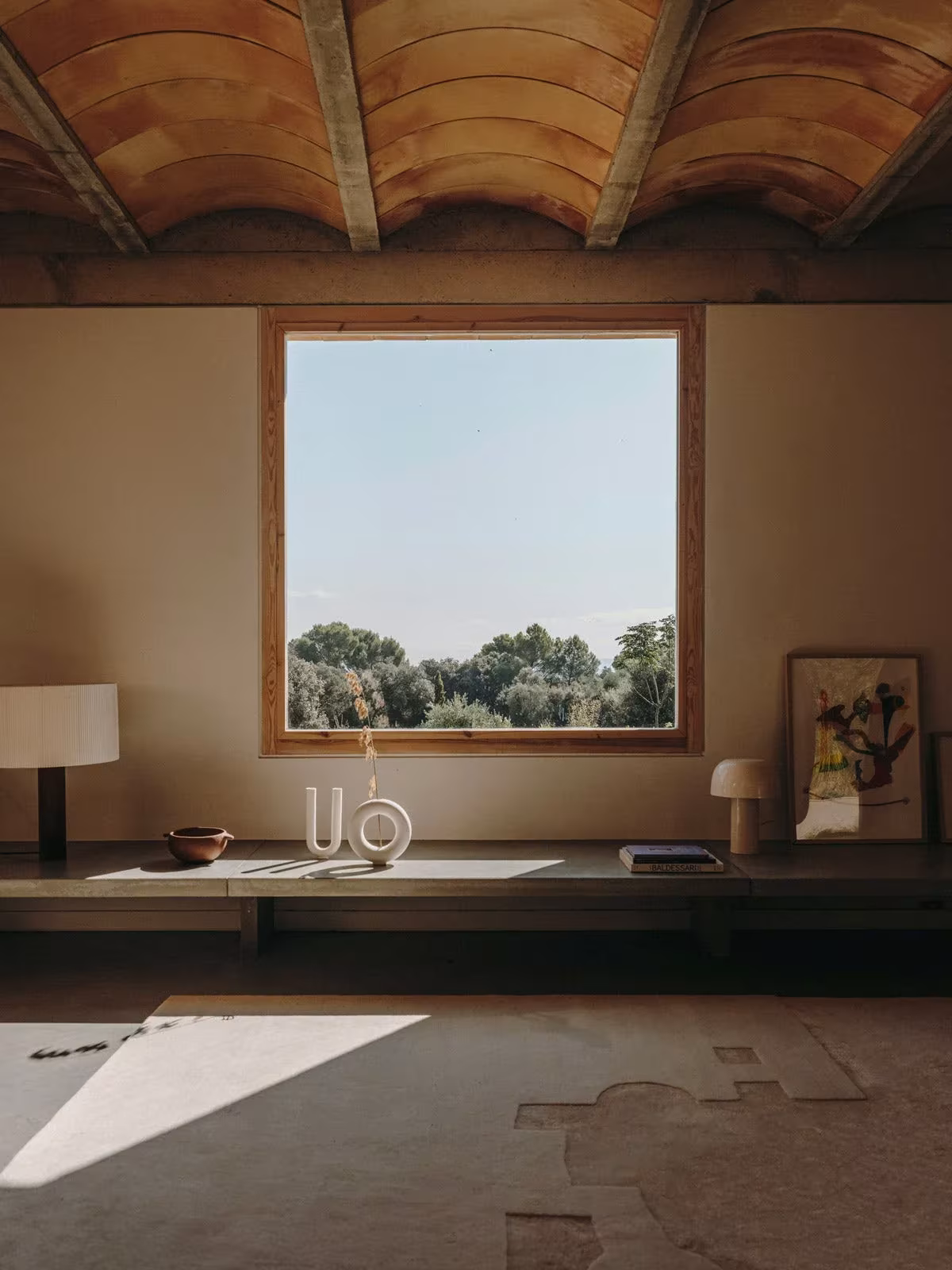 Estancia de la Casa Ter con bóveda cerámica, banco corrido y ventana cuadrada abierta al paisaje