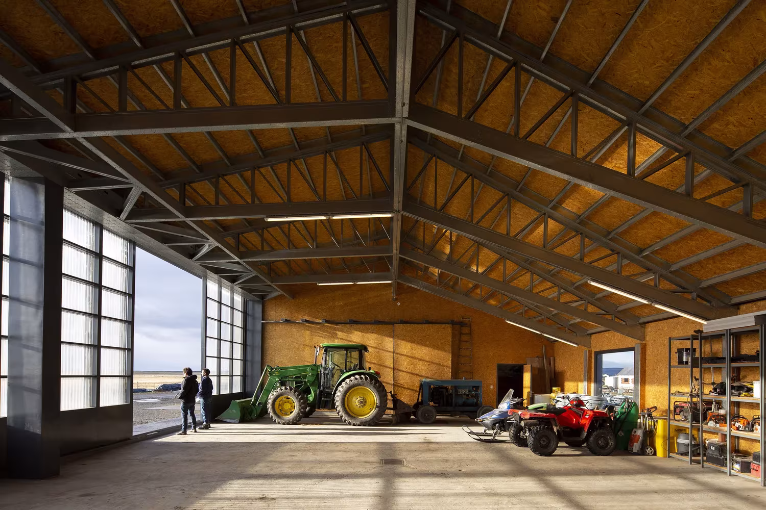 Cobertizo de maquinaria de la Estancia Morro Chico con cerchas metálicas, tractor y paneles translúcidos