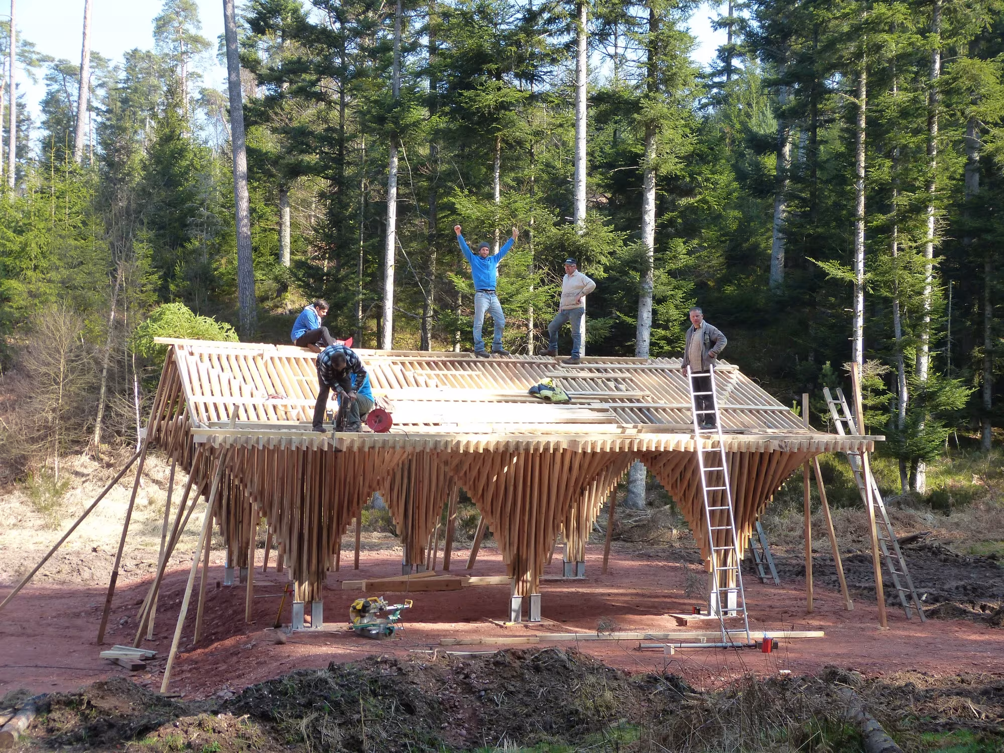 Montaje de la cubierta de listones del pabellón de Bertrichamps con voluntarios sobre la estructura