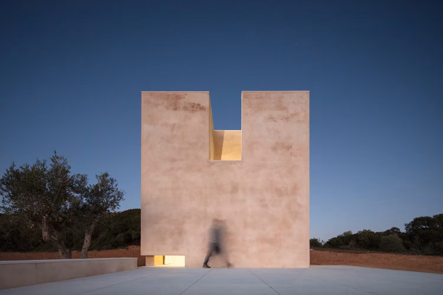 Fachada de la Capela do Monte de Siza con su hendidura superior, vista al anochecer en el Algarve