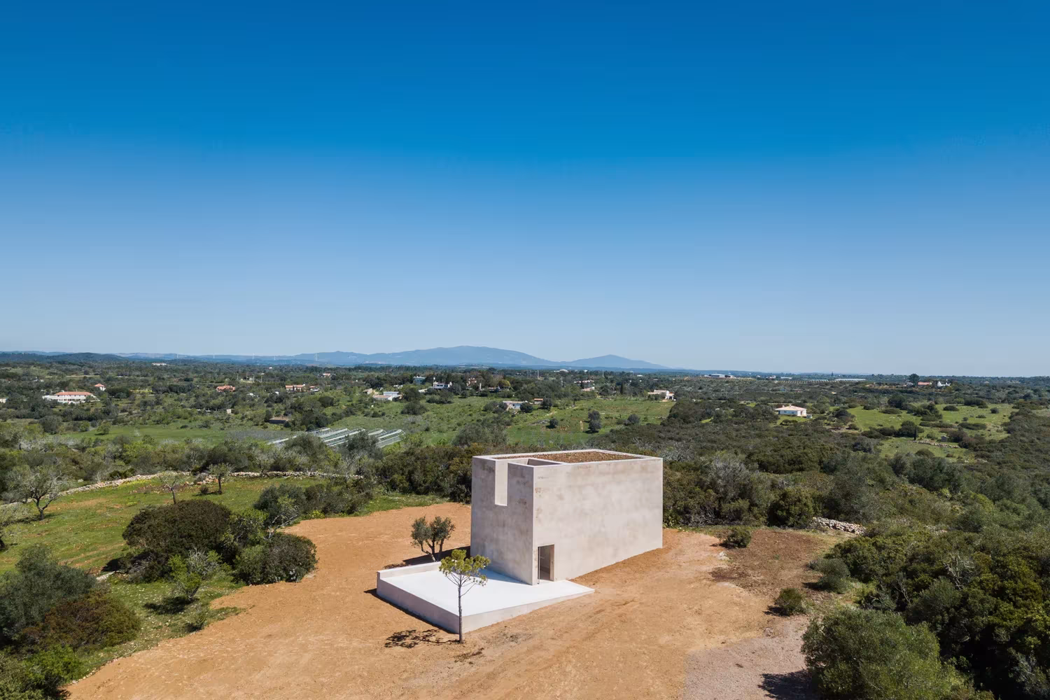 Vista elevada de la Capela do Monte rodeada de olivos y campo en el Algarve portugués