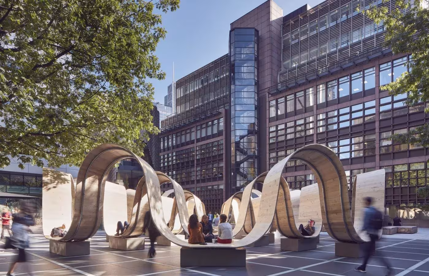 Anillos de madera curva de Please Be Seated de Paul Cocksedge en una plaza del distrito financiero de Londres