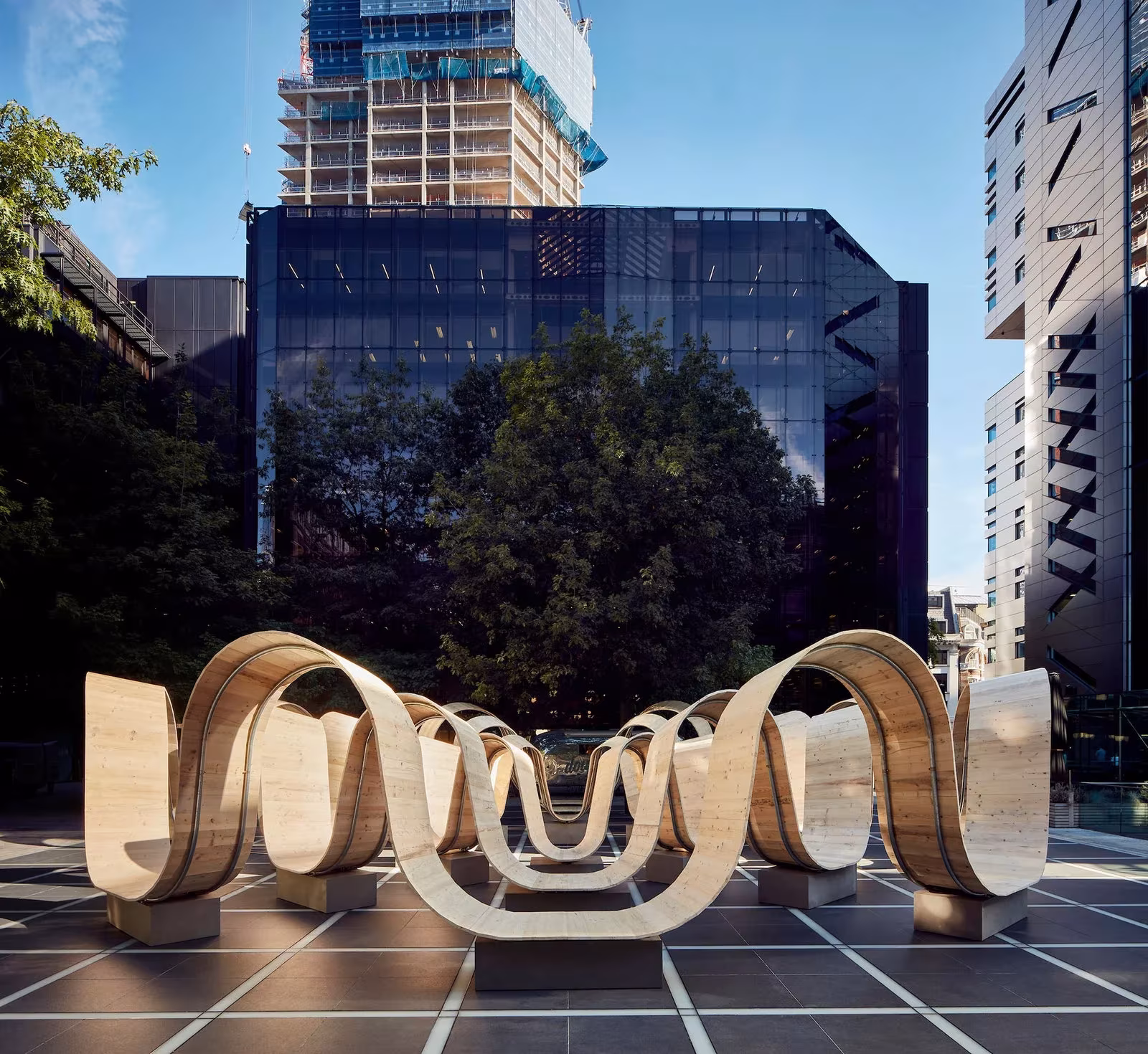 Please Be Seated, instalación de bancos ondulados de madera ante edificios de oficinas en Londres