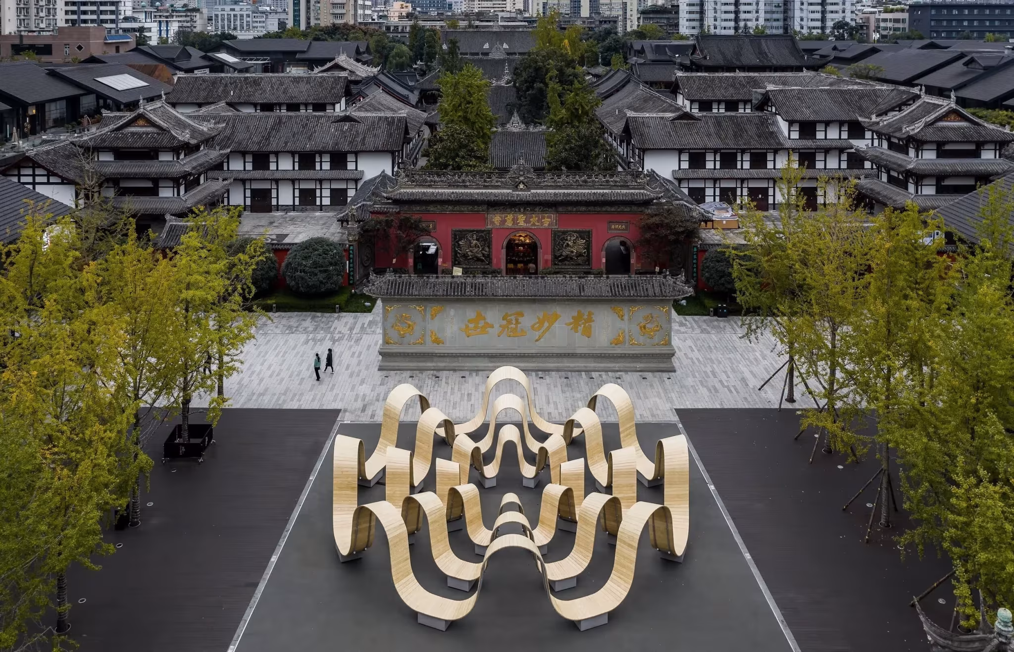 Vista aérea de Please Be Seated instalada ante un conjunto de edificios tradicionales en China