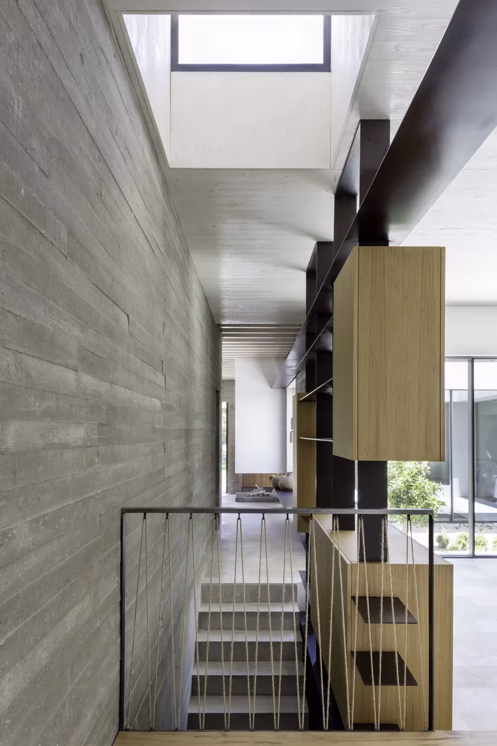 Escalera con muro de hormigón visto y lucernario en la vivienda unifamiliar Proyecto AS de Madrid