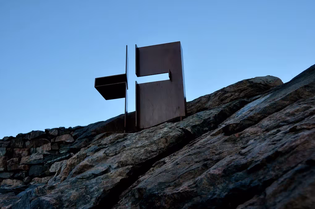 Cruz metálica de acero corten sobre la roca en la cubierta de Temppeliaukio, Helsinki