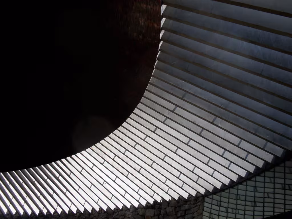 Curva de la claraboya perimetral de Temppeliaukio con luz entrando entre las lamas