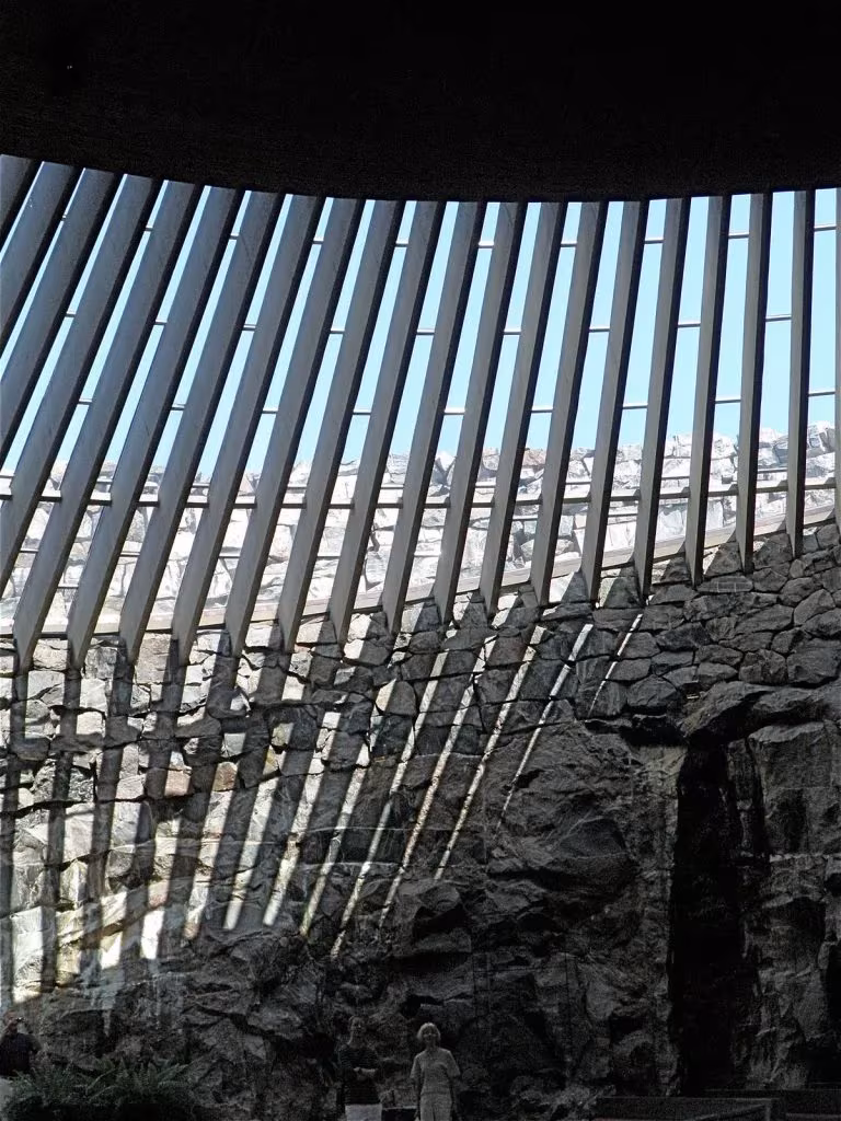 Lamas verticales de la claraboya y muro de roca natural en el interior de Temppeliaukio