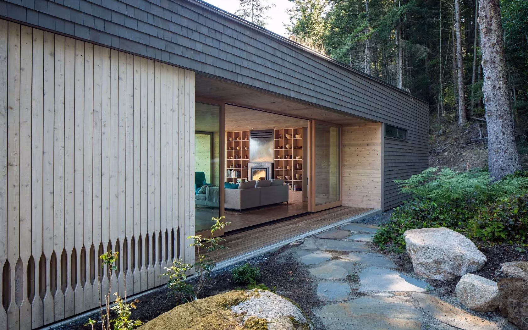 Fachada de listones de madera y sendero de losas de piedra hacia el salón abierto de Lone Madrone