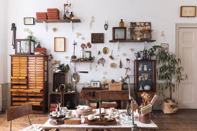 Estudio de Kaori Tatebayashi con cajoneras de madera, estantes y objetos naturales sobre la mesa