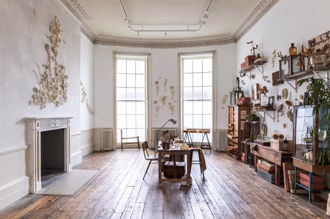 Sala georgiana con suelo de madera, grandes ventanales y relieve cerámico floral de Kaori Tatebayashi en The Walled Garden, Londres