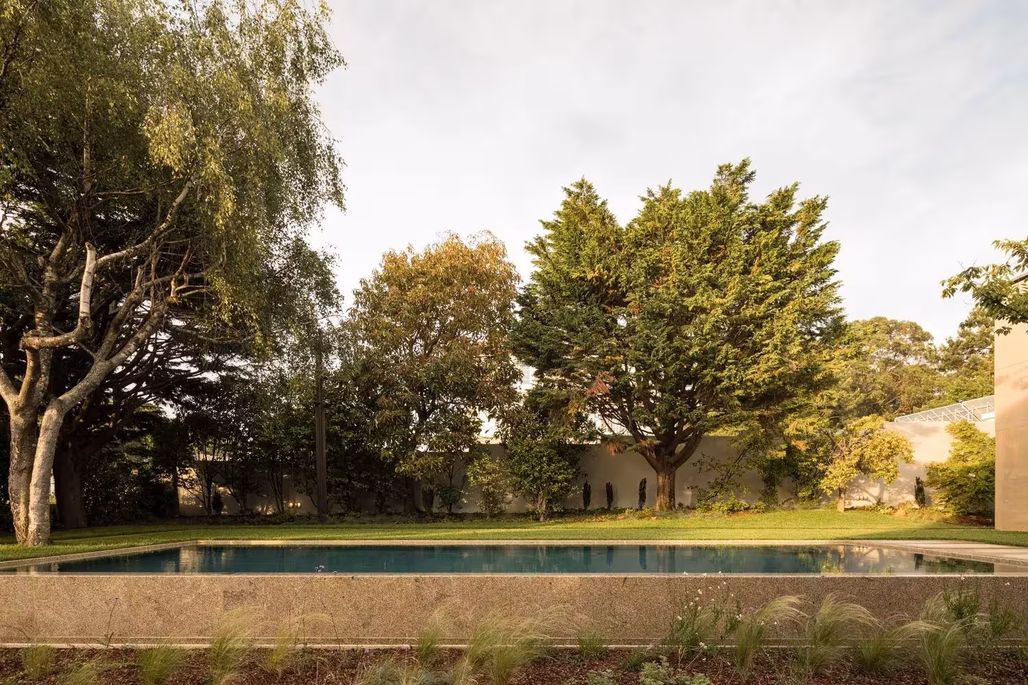 Piscina de la Casa 2 de Ricardo Bak Gordon rodeada de árboles en el jardín de una villa de Oporto