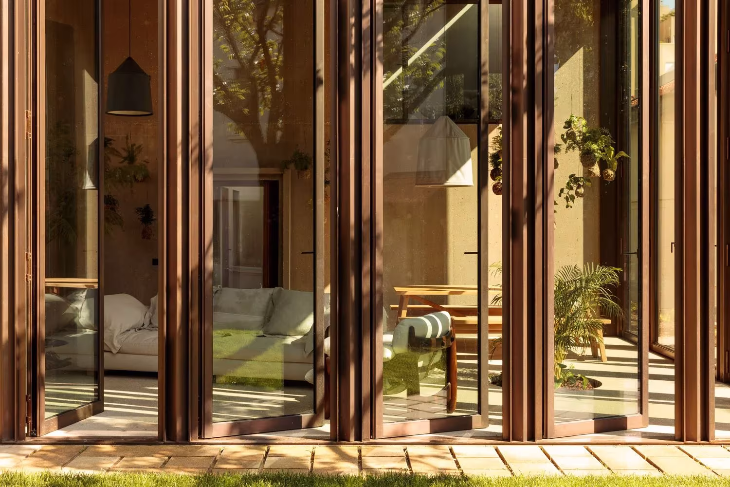 Pilares de madera y vidrio de la fachada del pabellón Casa 2 de Ricardo Bak Gordon, junto al jardín, Oporto