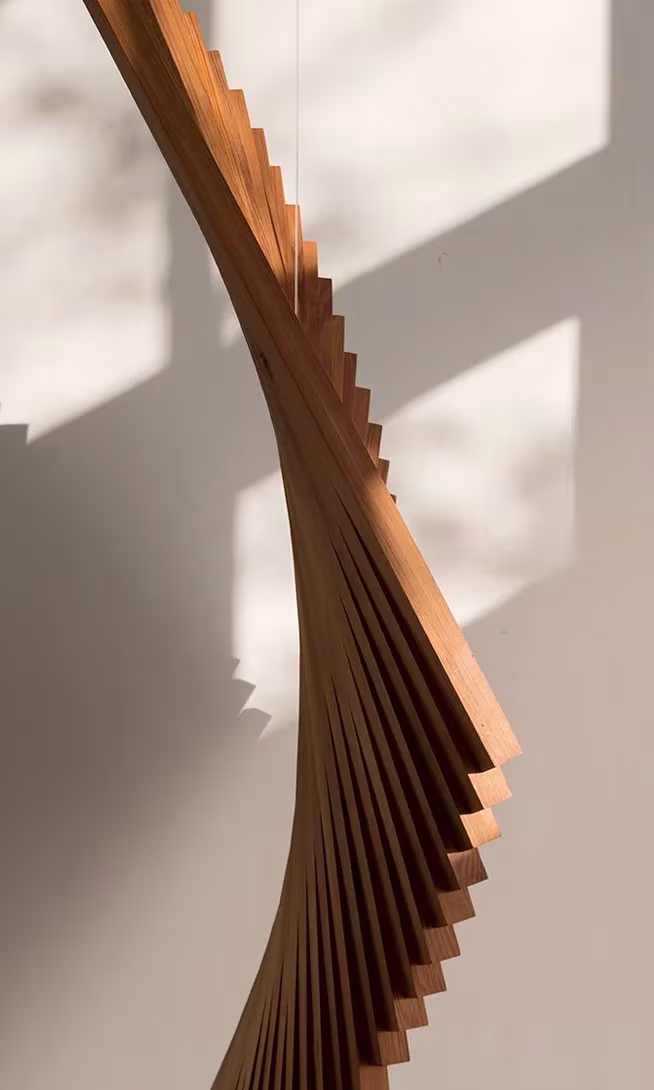 Detalle de una pieza de madera de láminas en espiral que forma una curva, obra de Carla Cascales