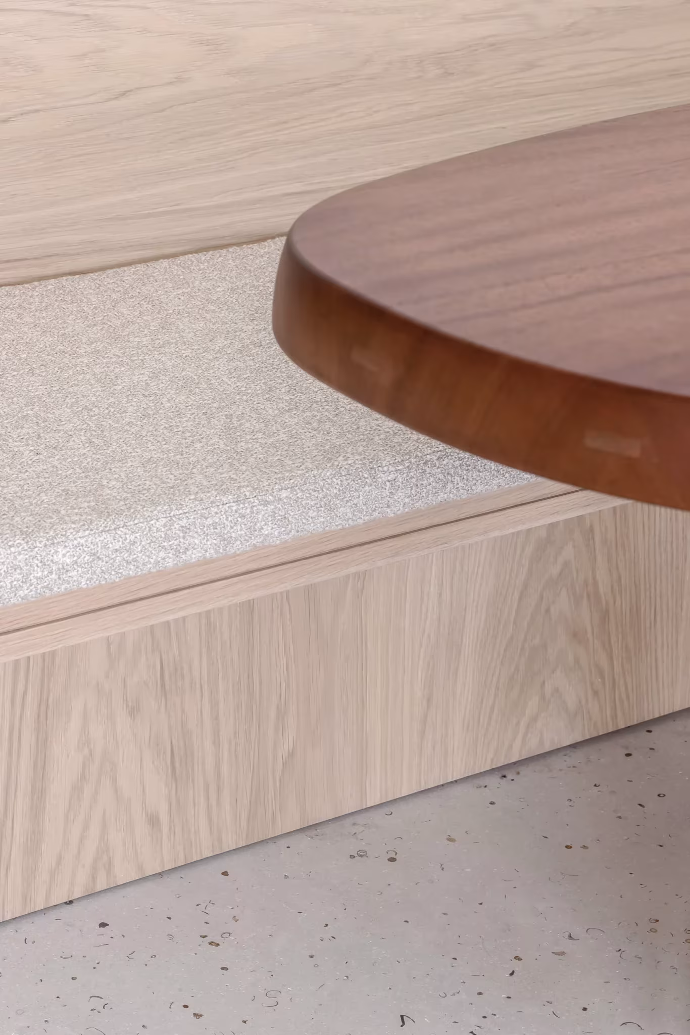 Detalle de la mesa de madera sobre un zócalo de roble y suelo de terrazo claro en el proyecto BUN