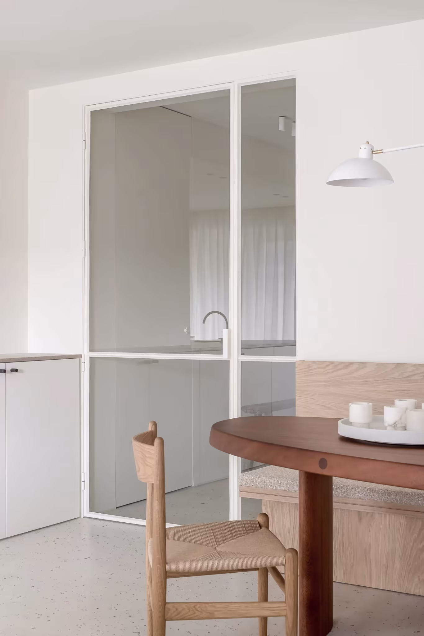 Puerta de vidrio y carpintería metálica junto al comedor en el piso BUN de Nils Van der Celen, en Knokke