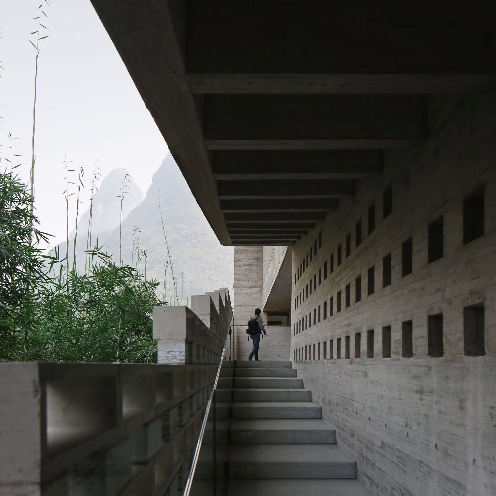 Escalera de hormigón visto junto a un muro perforado en el Hotel Alila Yangshuo de Vector Architects