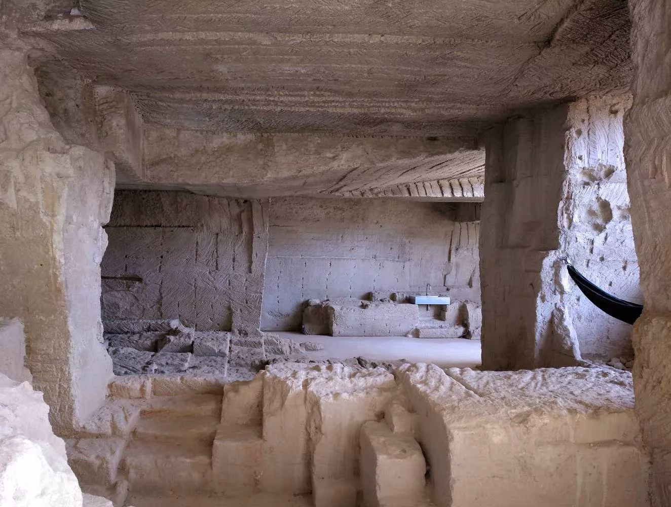 Interior de Ca'n Terra con bloques y escalones tallados en la piedra de Marés, de Ensamble Studio, en Menorca