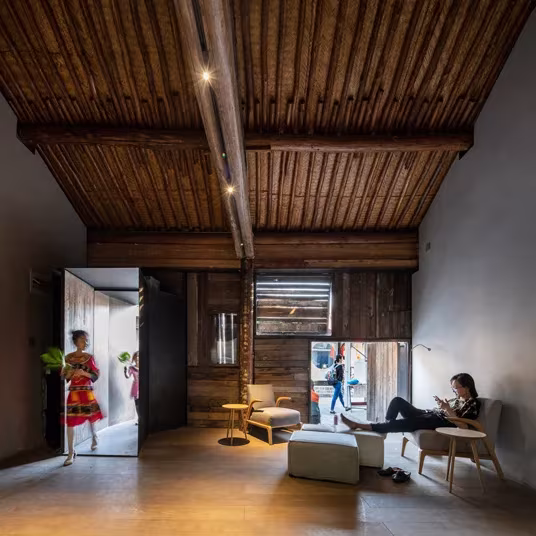 Sala de Micro Hutong con techo de vigas de madera antigua, zona de estar y puertas al callejón de Pekín