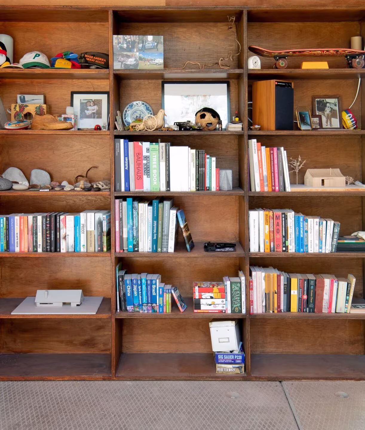 Estantería de madera con libros y objetos en el interior de Shady Shed, de Julius Taminiau Architects