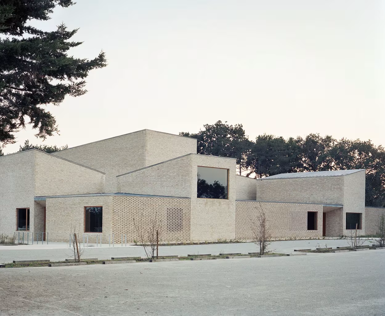Polideportivo de RAUM en Saint-Jean-de-Boiseau, de ladrillo claro y cubiertas a distintas alturas