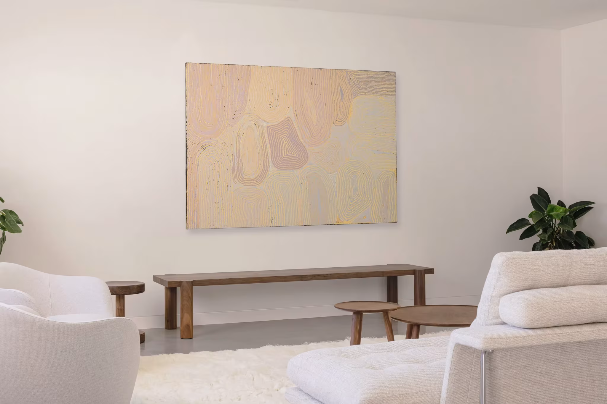 Sala con sofás blancos, banco de madera y una gran pintura de tonos pastel en la casa de Whispering Smith