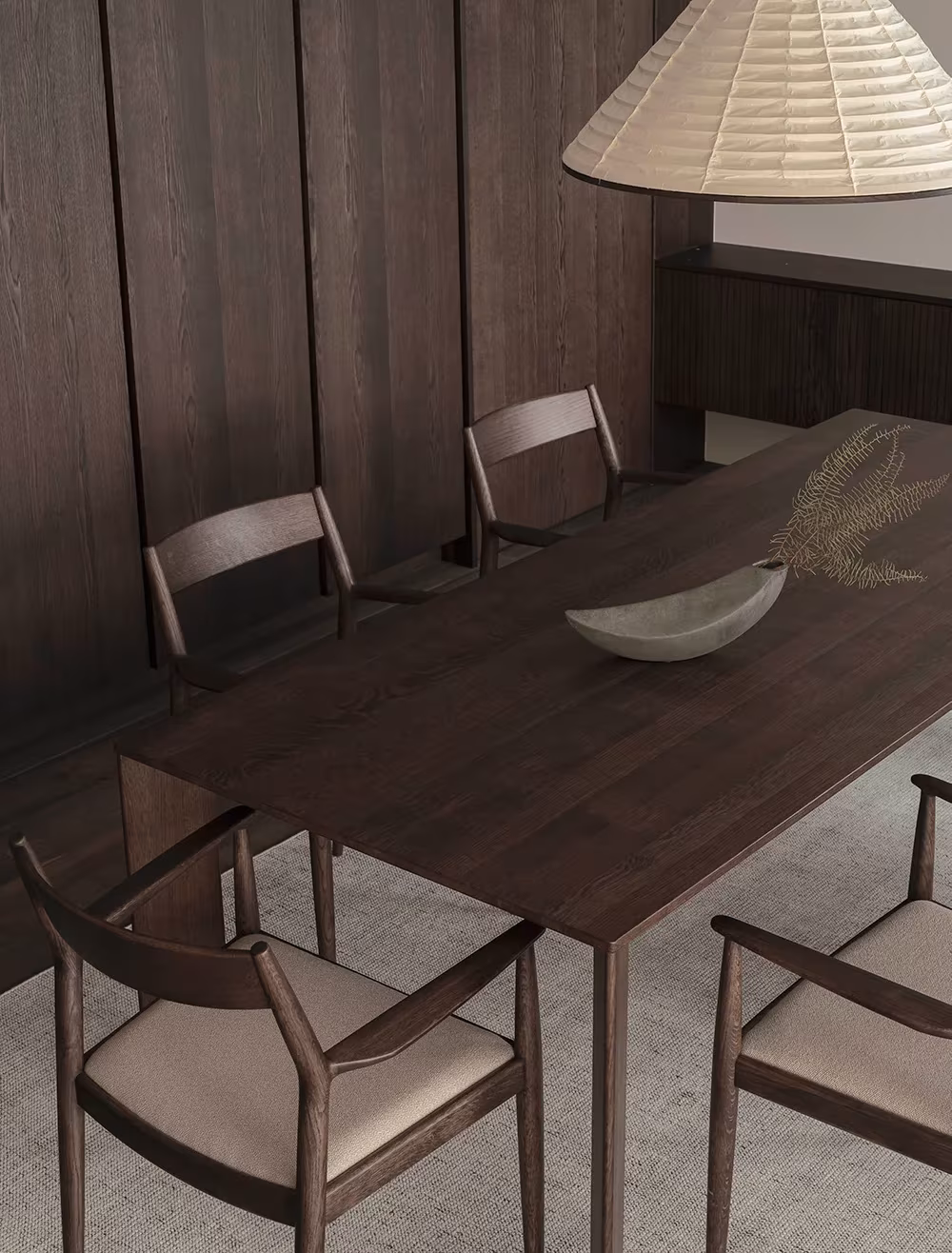 Mesa de comedor de madera oscura con sillas y lámpara de papel ante un muro de roble tintado en Azabu Residence