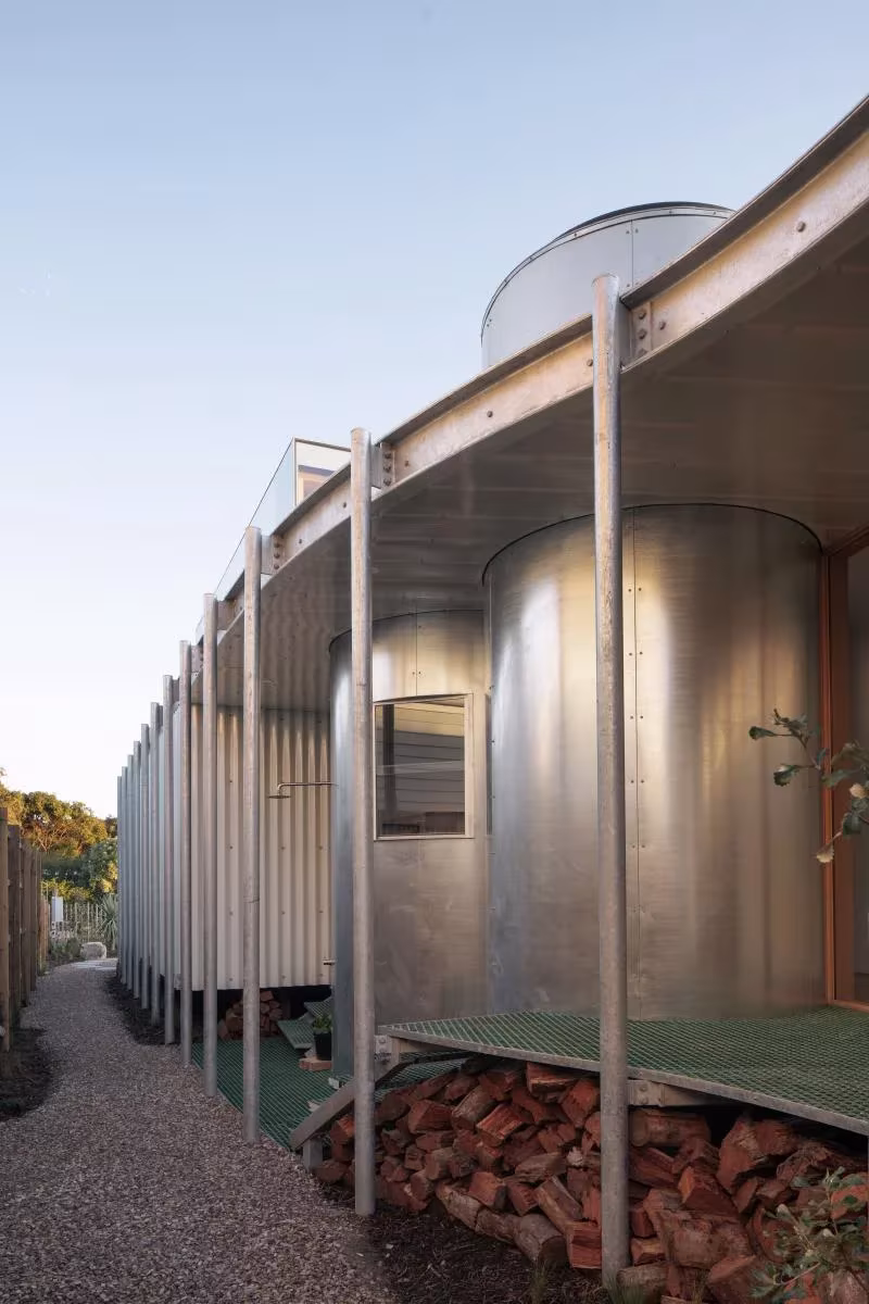 Depósito cilíndrico de chapa y cubierta ligera sobre pilares delgados en la Casa AB de Barwon Heads, Australia