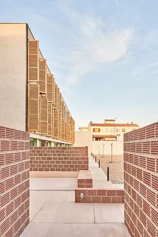 Bloque de viviendas de ladrillo cerámico y contraventanas de madera en el proyecto INCA de Alventosa Morell Arquitectes