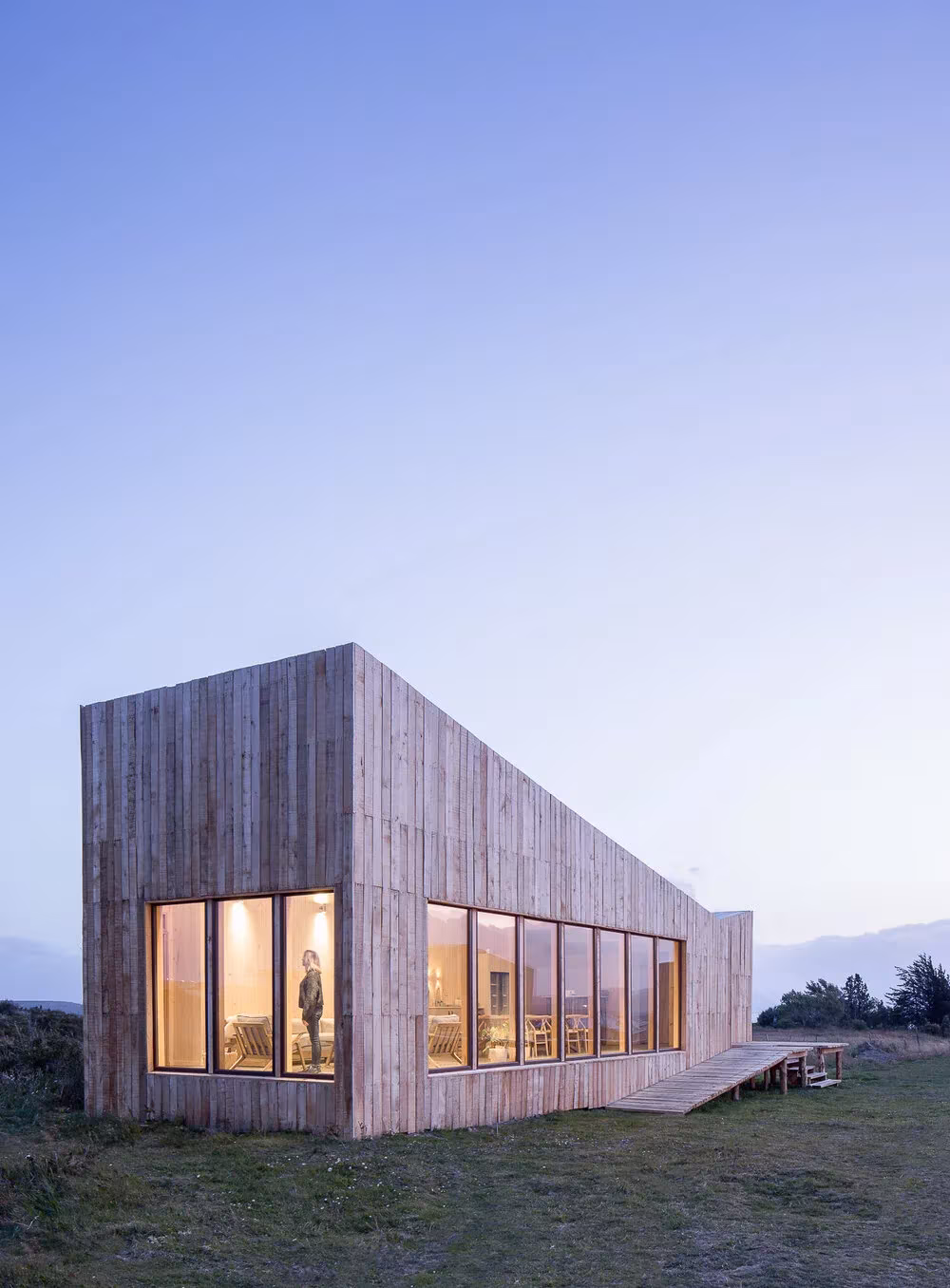 Proyecto AKA de Larrou Arq. Hotel Boutique en Puerto Natales, Chile. Atardeciendo y módulo iluminado en interior