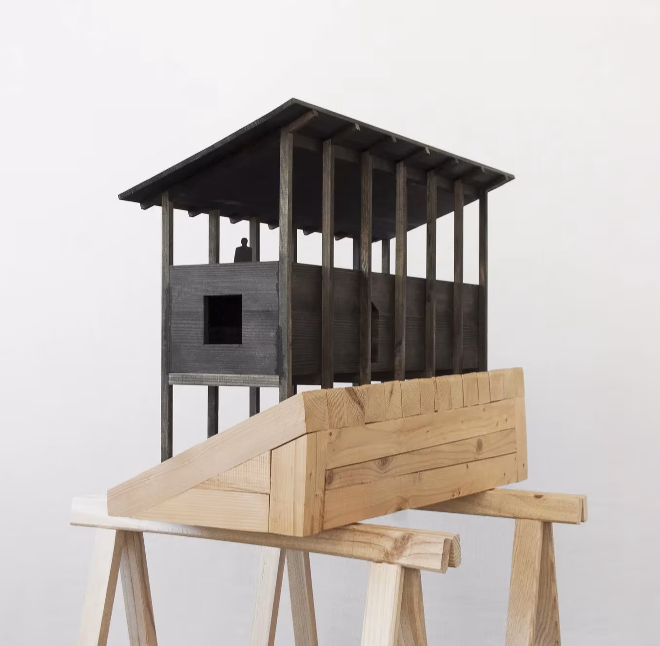 Maqueta en perspectiva de la casa de pilares de madera oscura de Treyvaux sobre una base escalonada