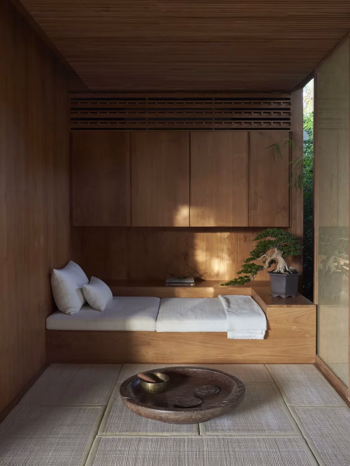 Habitación de HER con cama empotrada, tatami y cuenco de madera bajo un techo de madera