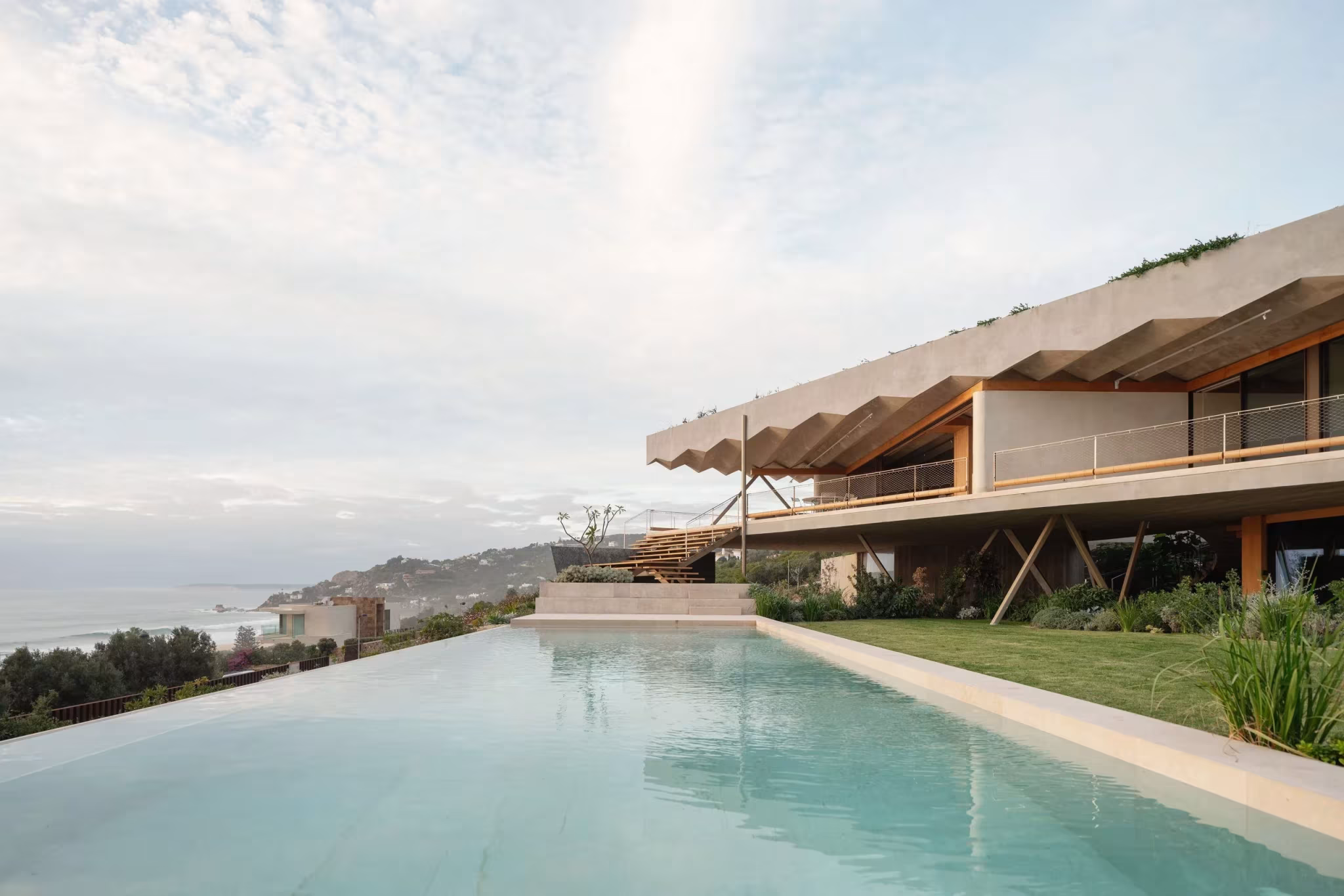 Piscina alargada ante el refugio de Langarita Navarro, con la cubierta plegada sobre la vivienda