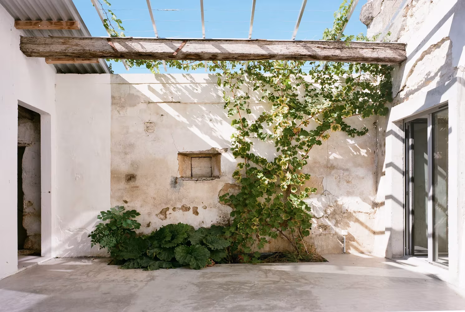 Patio nuevo al retirar una parte de la cubierta en la transformación de un granero en una casa de vacaciones en Francia de Migeon Architecture. 