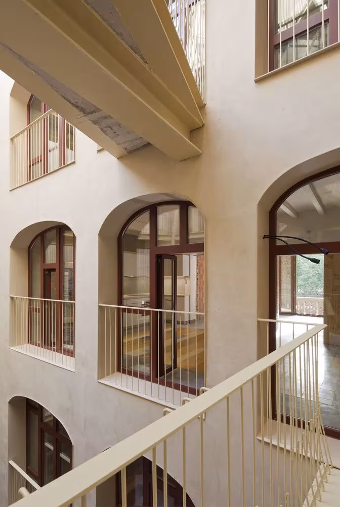 Pasarelas de la escalera abiertas al patio de La Carbonería, con ventanas arqueadas y barandillas ligeras