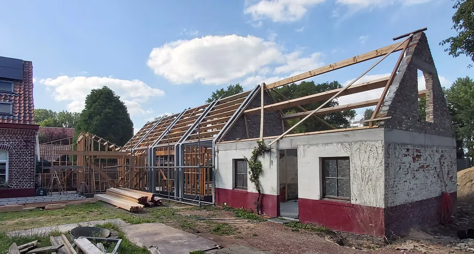 Granero de Gijzenzele en obra, con la estructura de la cubierta al descubierto, de Atelier Tom Vanhee