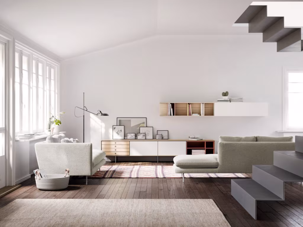 Double-height living room with a cantilevered stair, a suspended white unit and a pale sofa on dark parquet