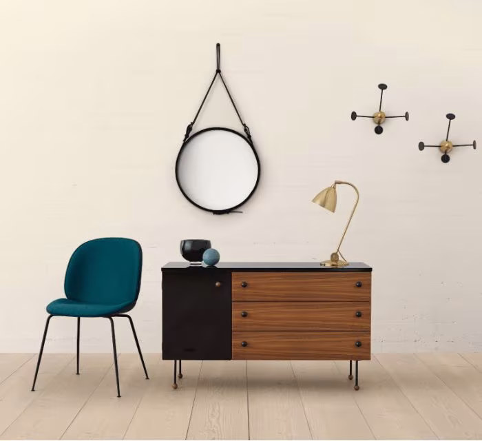 Aparador de madera y negro con espejo redondo, silla Beetle azul y lámpara de latón de diseño escandinavo