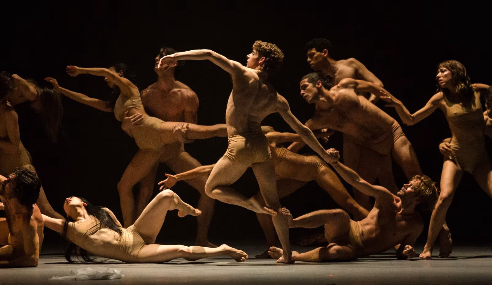 Bailarines entrelazados en una composición escultórica sobre el escenario en In Paradisum, de Antonio Ruz