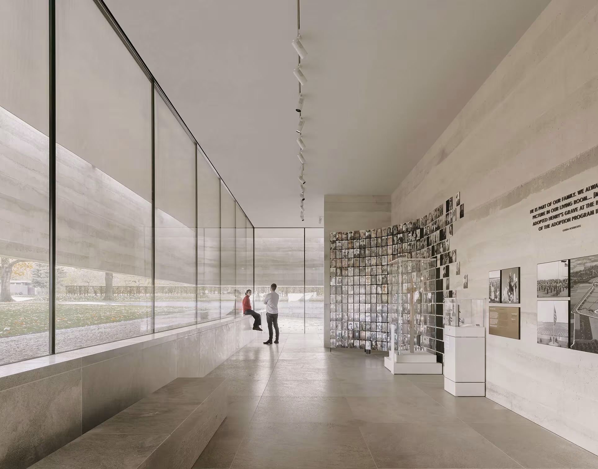 Sala expositiva del Centro de Visitantes del Cementerio Americano con vidrio corrido y gradas de hormigón