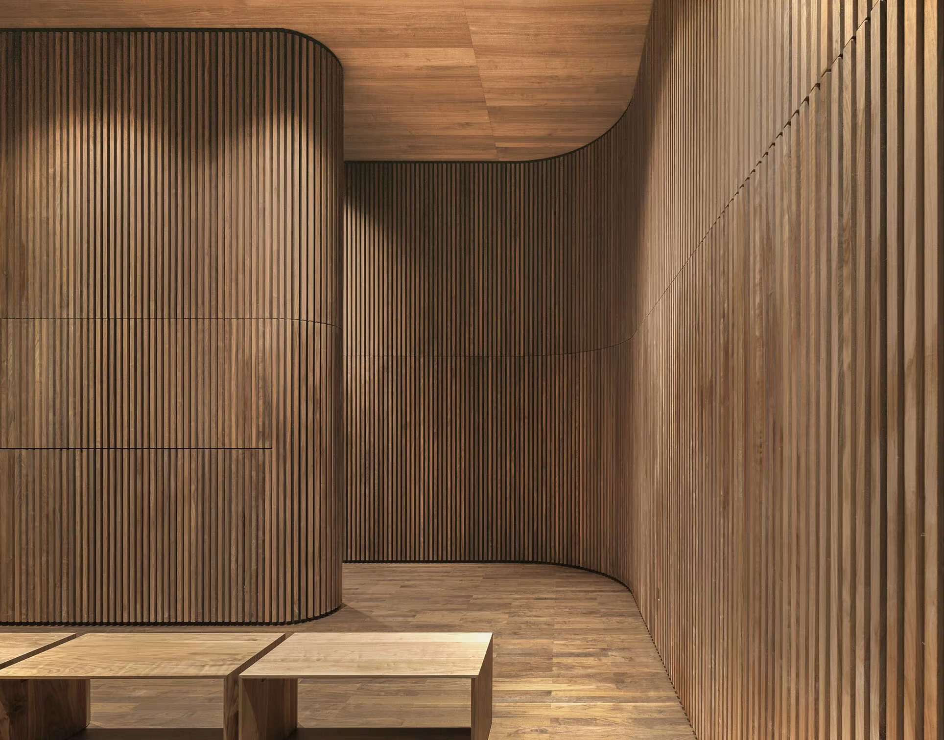 Sala curva revestida de listones de madera con bancos bajos en el Centro de Visitantes de KAAN Architecten