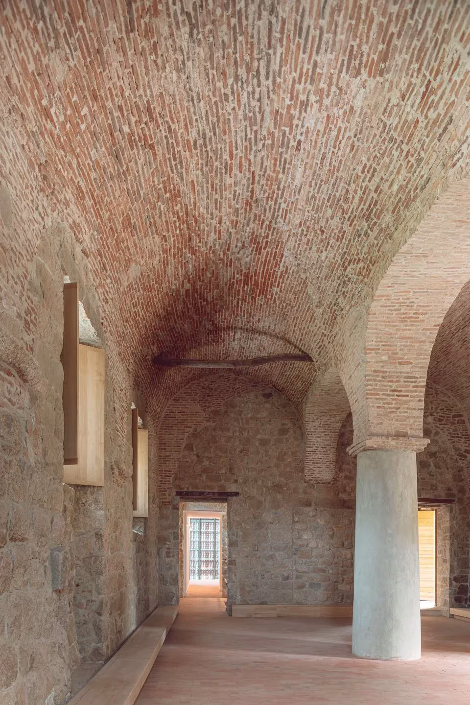 Nave con bóveda de ladrillo, arcos de piedra y una gran columna redonda en el Convento Saint-François