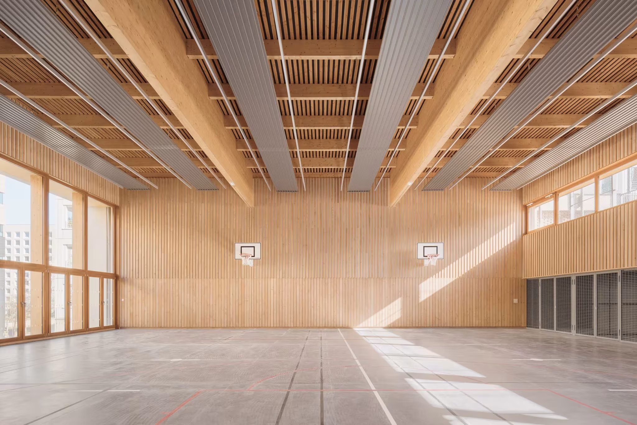 Gimnasio con estructura de vigas de madera laminada, canastas y revestimiento de listones en el mercado reciclado de Lyon