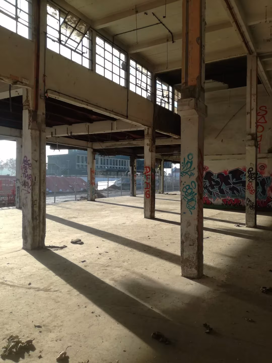 Nave abandonada del antiguo mercado de Lyon con pilares, ventanales altos y grafitis