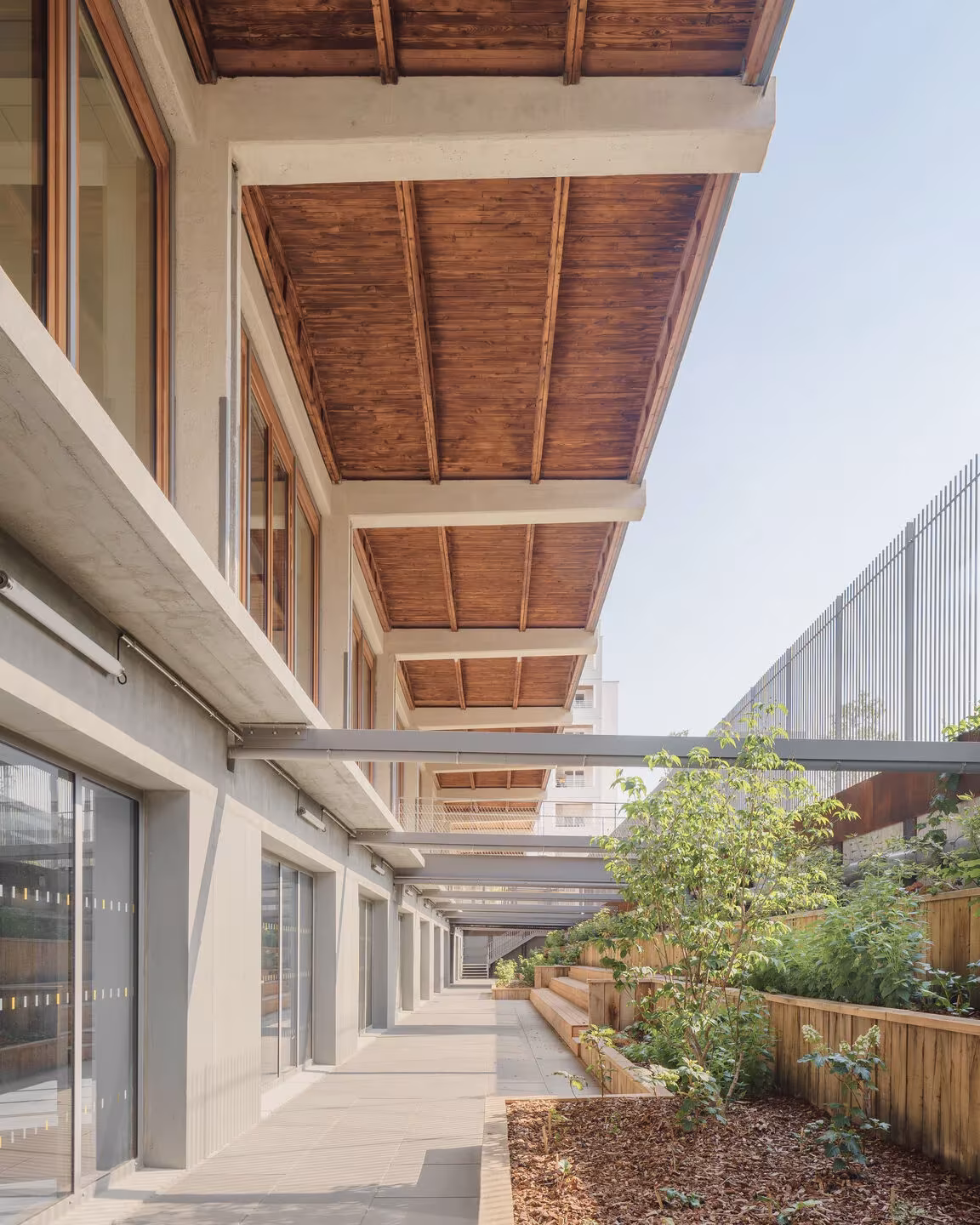 Galería exterior con voladizo de madera y jardineras junto a la fachada del edificio reciclado de Lyon