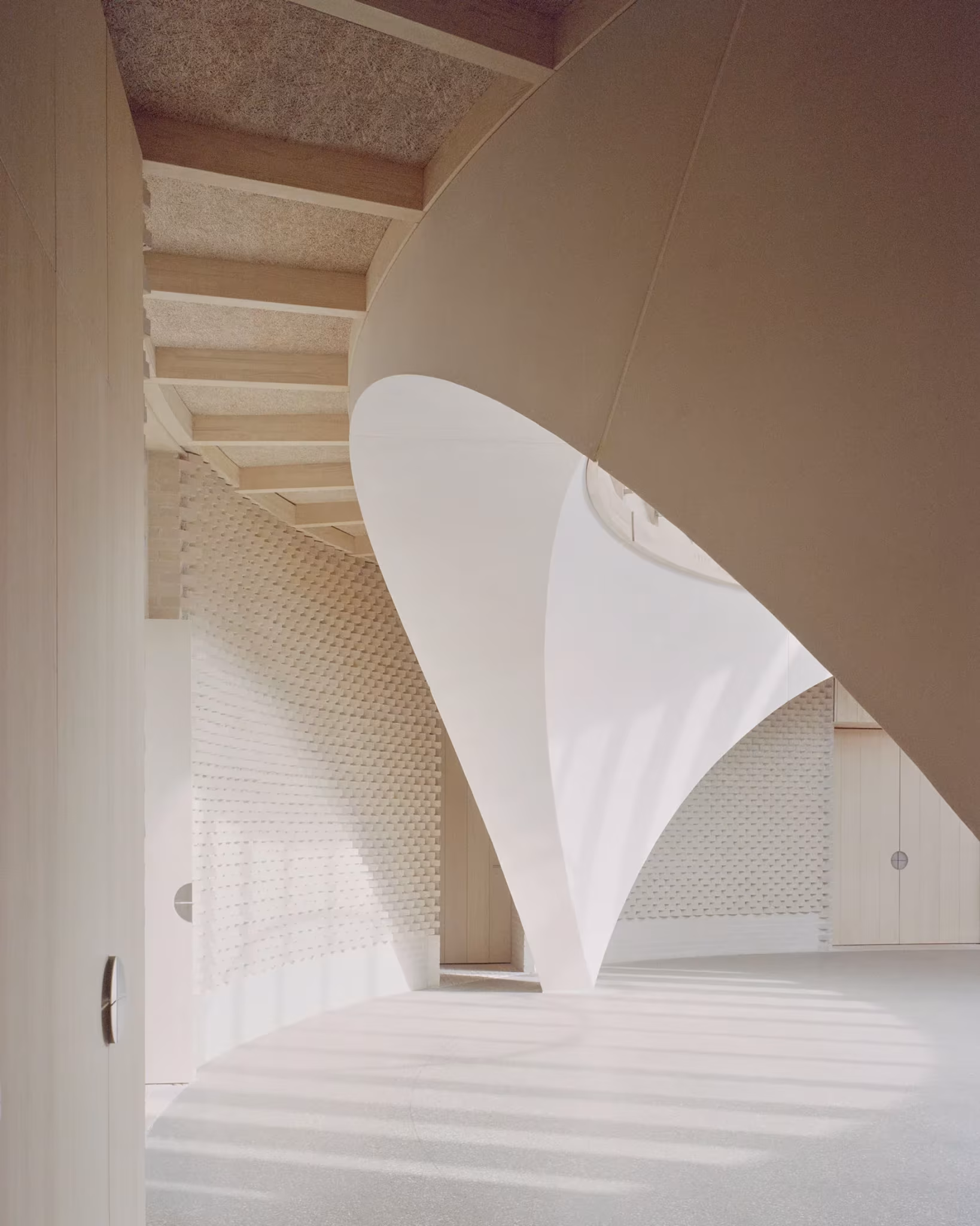 Pilar blanco en forma de cáliz que recoge la bóveda de madera en el interior del New Temple Complex