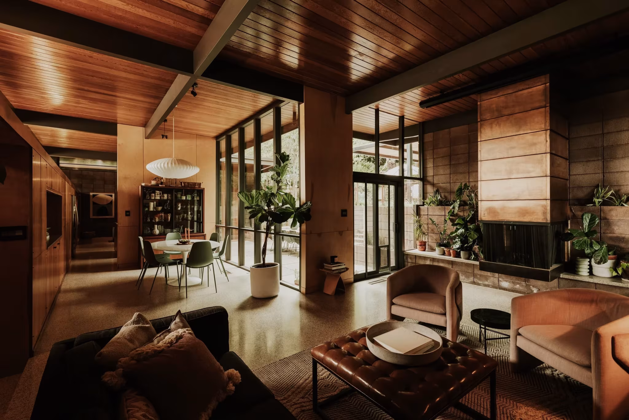 Vista de conjunto del comedor y el salón de la Residencia Nittler bajo vigas de acero y techo de madera