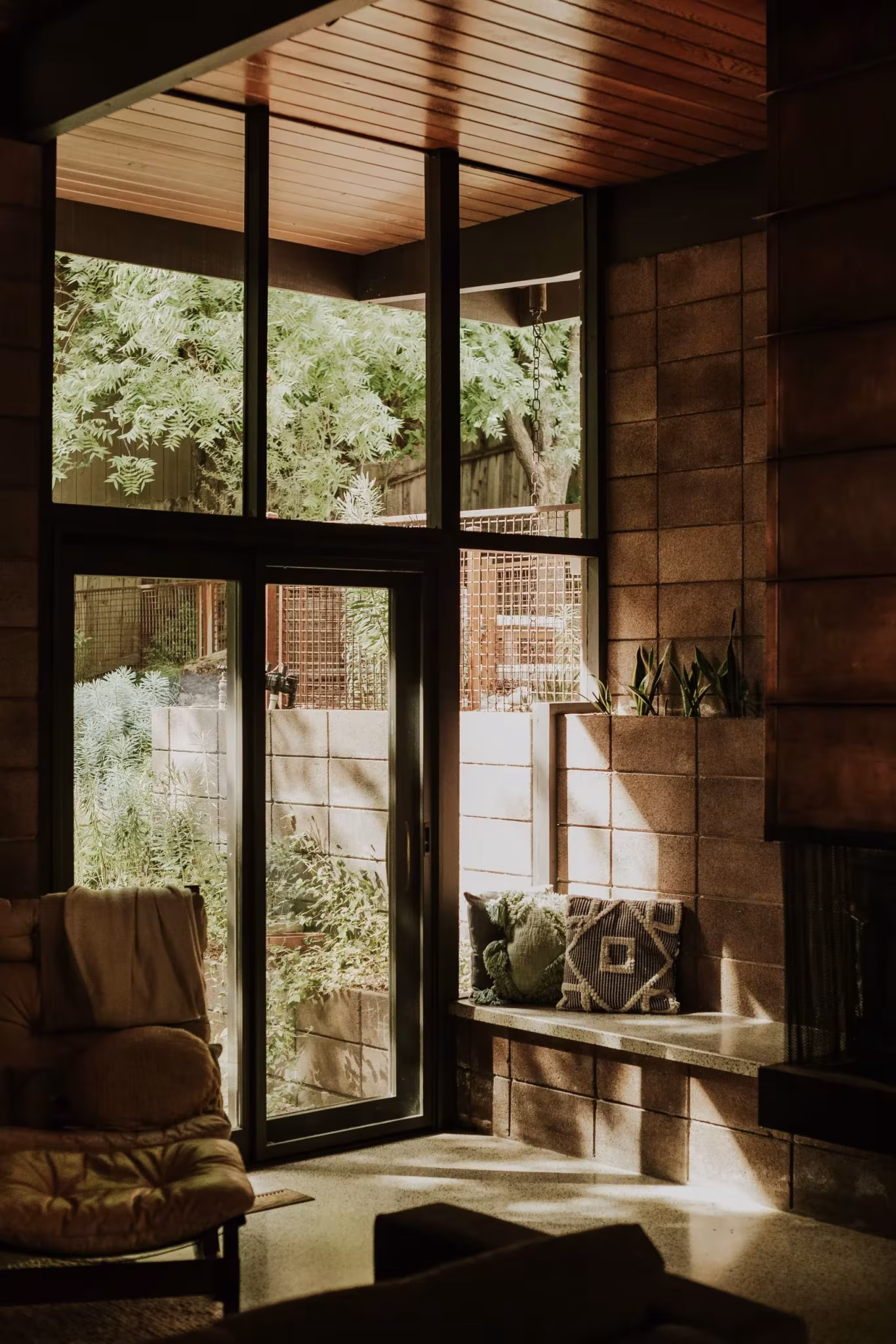 Esquina acristalada del salón de la Residencia Nittler con banco corrido y vistas al jardín